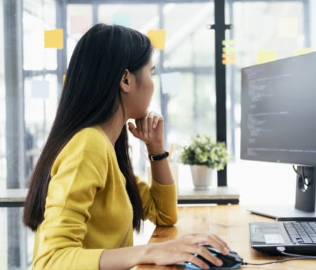 Person coding on computer in office