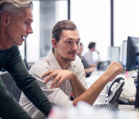 Person helping someone else on computer