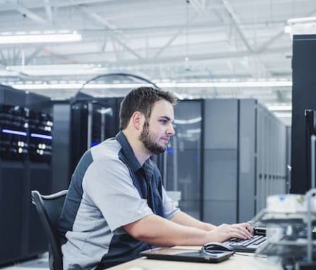 Man working on computer in server room