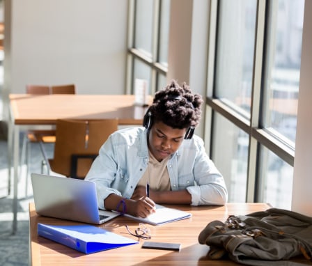 Teenage boy studies in school library