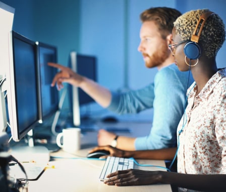 Two colleagues coding on computers